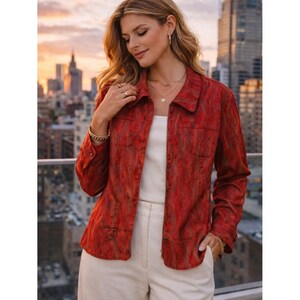 May include: A long-sleeved button-down jacket in a deep red hue with a subtle, repeating vertical pattern. The jacket features a classic collar, a single chest pocket, and buttoned cuffs, worn over a plain white top and light-colored trousers.