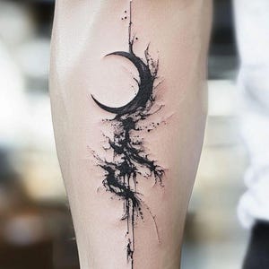 Puede incluir: Tatuaje negro de una luna creciente con un diseño abstracto de salpicaduras de tinta. El tatuaje está en el brazo, con una línea vertical que se extiende desde la luna. El diseño tiene una estética oscura y artística.