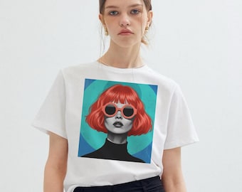 May include: White t-shirt featuring a graphic of a woman with red hair and sunglasses. The artwork has a retro style with a teal and blue background. The woman is wearing a black turtleneck.
