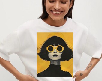 May include: White t-shirt featuring a graphic of a woman with black hair and yellow sunglasses against a yellow background. The woman is wearing a black turtleneck. The image has a modern, artistic style.