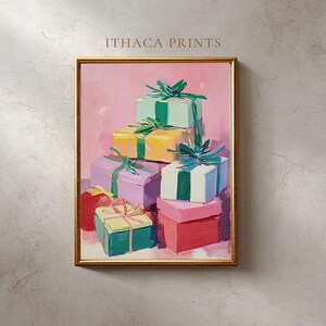 Könnte beinhalten: Gerahmtes Gemälde mit bunten Geschenkboxen, die übereinander gestapelt sind. Die Geschenke sind in Grün, Gelb, Rosa, Lila und Rot gemalt, jedes mit einem kontrastierenden Band. Der Hintergrund ist ein zartes Rosa, und der Rahmen ist goldfarben. Der Text "ITHACA PRINTS" steht oben.
