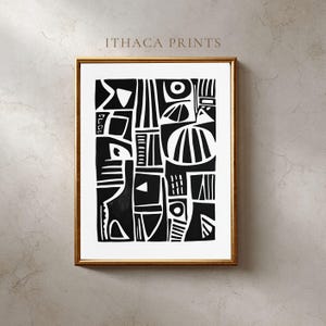 Puede incluir: Impresión artística abstracta en blanco y negro en un marco dorado. La obra de arte presenta formas y patrones geométricos. El texto "ITHACA PRINTS" está en la parte superior de la impresión. La impresión se muestra en una pared de color neutro.