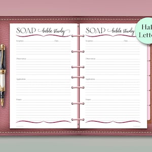 May include: A pink leather-bound journal with a pen, featuring a "SOAP bible study" layout. The journal has lined pages for scripture, observation, application, and prayer. A "Half Letter" sticker is on the right.