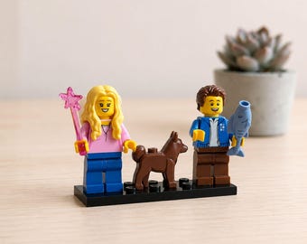 Może przedstawiać: Dwie minifigurki LEGO stojące na czarnej podstawie z brązowym psem. Lewa figurka ma długie blond włosy, różową koszulkę i niebieskie spodnie, trzymając różową różdżkę w kształcie gwiazdy. Prawa figurka ma brązowe włosy, niebieską kurtkę i brązowe spodnie, trzymając niebieską rybę.
