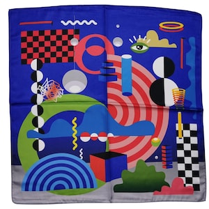 May include: A square, blue scarf with a colorful abstract design. The design includes red and white concentric circles, a black and red checkered square, and various geometric shapes in green, blue, and white. The scarf has a gray border.