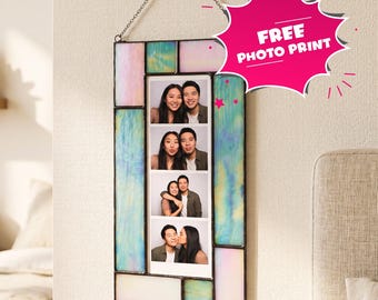 May include: A rectangular stained glass photo frame with iridescent pastel panels in shades of blue, pink, and white. The frame hangs from a metal chain on a wall hook and contains a vertical strip of four photos of a couple.