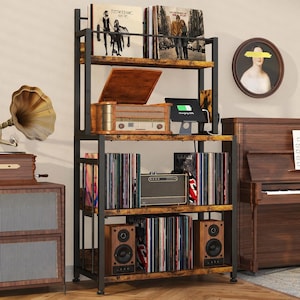 May include: A multi-tiered, rustic-style shelving unit with black metal frame and wooden shelves. The shelves display vinyl records, a vintage record player, speakers, and a small amplifier. Two vinyl record albums are on the top shelf.