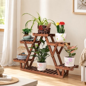 May include: A multi-tiered wooden plant stand with a dark brown finish, featuring a geometric, angular frame. It holds six potted plants of various sizes, including a spider plant, a cactus, and several leafy green plants in decorative ceramic pots.