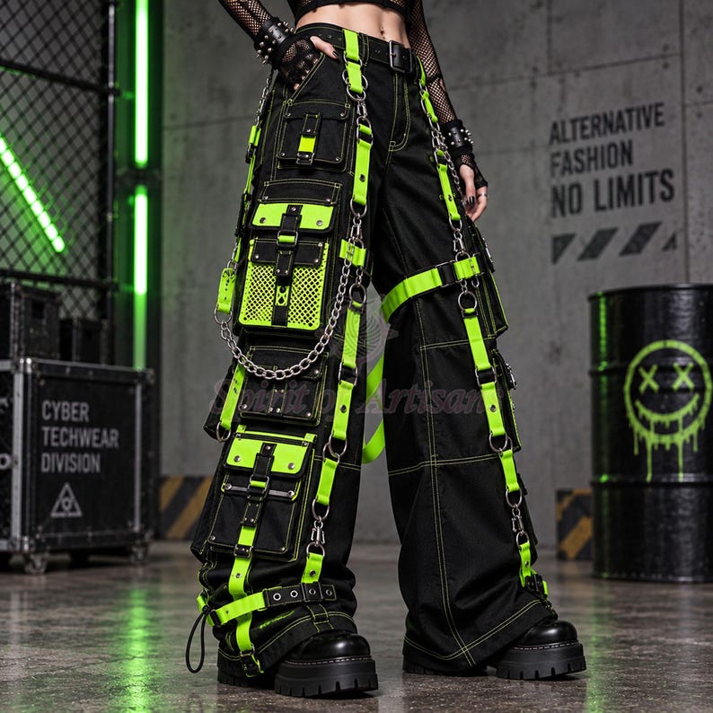 black cyberpunk techwear cargo pants with vivid neon green straps, layered utility pockets, mesh panels, metal chains, D-rings, buckles and zipper details. The oversized wide-leg silhouette creates a dramatic cyber goth and industrial punk look, while multiple pocket sections and hanging hardware make these baggy cargo pants ideal for rave, festival, techno and alternative streetwear styling.