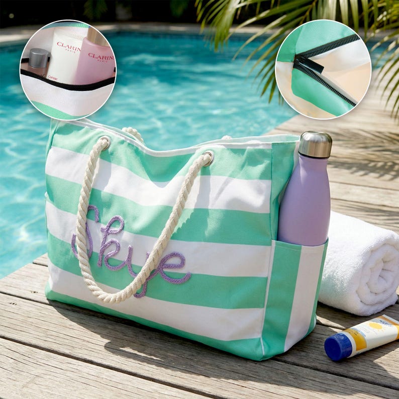May include: A mint green and white striped canvas tote bag with thick white rope handles and the name Skye embroidered in purple script on the front. The bag features a side pocket holding a lavender water bottle, a zipper closure, and an interior.