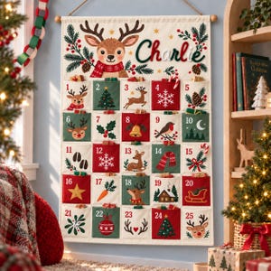 Pode incluir: Um calendário do advento de tecido cor de creme para pendurar na parede com o nome Charlie em letra verde. Possui vinte e cinco bolsos numerados decorados com ilustrações festivas, incluindo renas, pinheiros, flocos de neve e ícones natalinos.