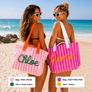 K&ouml;nnte beinhalten: Zwei rechteckige Tragetaschen mit vertikalen Streifen. Die erste Tasche ist rosa und cremefarben mit orangefarbenen Tr&auml;gern und dem Namen Chloe, der in grasgr&uuml;nem Garn gestickt ist. Die zweite Tasche ist dunkelrosa und rosa mit wei&szlig;en Tr&auml;gern und dem Namen Romie in Gelb.