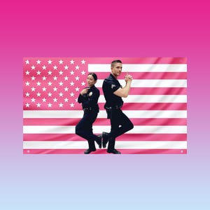 Può includere: Due persone in uniforme della polizia posano davanti a una bandiera americana rosa. La bandiera ha stelle e strisce bianche. Le persone indossano uniformi nere con distintivi e accessori. Lo sfondo è una sfumatura di rosa e blu.