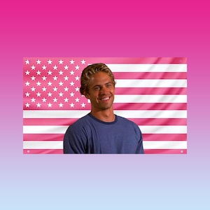 May include: A person in a blue top smiles in front of a pink American flag. The flag features white stars and pink stripes. The background has a pink and blue gradient.