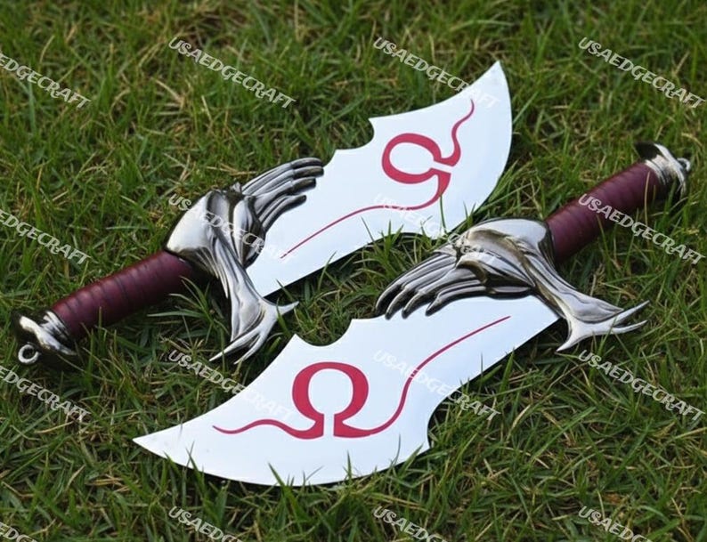 May include: Two silver-colored blades with a red handle and a stylized hand-shaped guard. The blades have a curved design with a red Omega symbol. The blades are displayed on a bed of green grass.