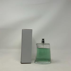 Può includere: Una tazza di ceramica bianca con un manico nero e la scritta "But First, Coffee" in nero, con un carattere a mano. La tazza è su una superficie bianca.