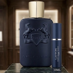 May include: A navy blue perfume bottle with a gold cap and a matching travel-size spray bottle. The large bottle features embossed horse imagery and the text "PARFUMS de MARLY". The travel spray is labeled "LAYTON PARFUMS de MARLY PARIS" and is 10ML.