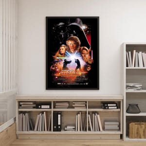 Puede incluir: Un póster enmarcado de la película Star Wars: Episodio III - La venganza de los Sith. El póster presenta a Darth Vader, Anakin Skywalker, Obi-Wan Kenobi y otros personajes. El póster está en un marco negro y se muestra en una pared blanca.