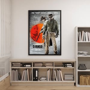 Może przedstawiać: Oprawiony plakat filmowy do filmu "Django Unchained" wisi na białej ścianie. Plakat przedstawia dwóch mężczyzn w kapeluszach kowbojskich, jeden trzyma broń. Tło to mieszanka szarości i pomarańczy, z wyraźnie widocznym tytułem filmu.