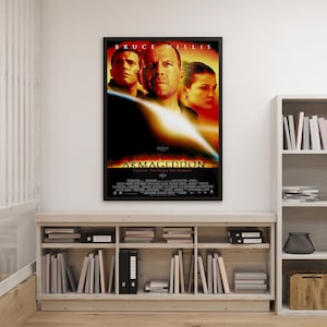 Può includere: Un poster cinematografico incorniciato del film "Armageddon" con Bruce Willis. Il poster ha una cornice nera ed è appeso a una parete bianca. Il design del poster include immagini degli attori e il titolo del film.
