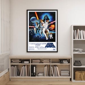 May include: A framed Star Wars film poster. The poster shows a dark background with characters in the foreground, including Darth Vader, Luke Skywalker, and Princess Leia. The title "Star Wars" is prominently displayed.
