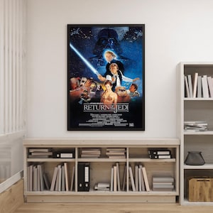 Puede incluir: Un póster enmarcado de la película "Star Wars: El Retorno del Jedi" cuelga de una pared blanca. El póster presenta a Luke Skywalker con un sable de luz, Darth Vader y otros personajes. El póster está encima de una estantería de madera.