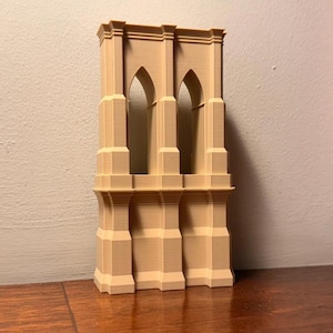 Könnte beinhalten: Beiges 3D-gedrucktes Modell eines Brückenturms mit drei bogenförmigen Öffnungen. Das Modell hat eine detaillierte, strukturierte Oberfläche, die einer Steinstruktur ähnelt. Das Architekturmodell ist ein dekorativer Gegenstand.