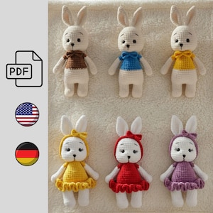 Könnte beinhalten: Sechs handgefertigte Häkelkaninchen-Puppen in verschiedenen Outfits. Die Hasen sind hauptsächlich weiß mit verschiedenfarbigen Oberteilen und Kleidern, darunter Braun, Blau, Gelb, Rot und Lila. Jeder Hase hat schwarze Augen und eine kleine Fliege oder Schleife. Das Bild enthält auch ein PDF-Symbol und ein amerikanisches Flaggen-Symbol.