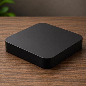 May include: A solid matte black square object with rounded corners and a smooth, flat top surface. The item features a low-profile design with vertical sides, presenting a clean and uniform appearance without any visible markings, buttons, or textures.