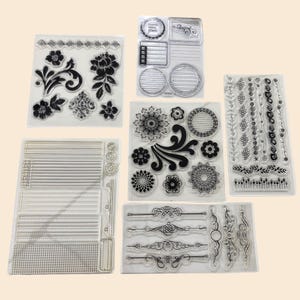 May include: Clear acrylic stamps featuring various decorative designs. The stamps include floral patterns, borders, and geometric shapes. The designs are in black and are arranged on clear sheets for easy alignment. Ideal for scrapbooking and crafting projects.