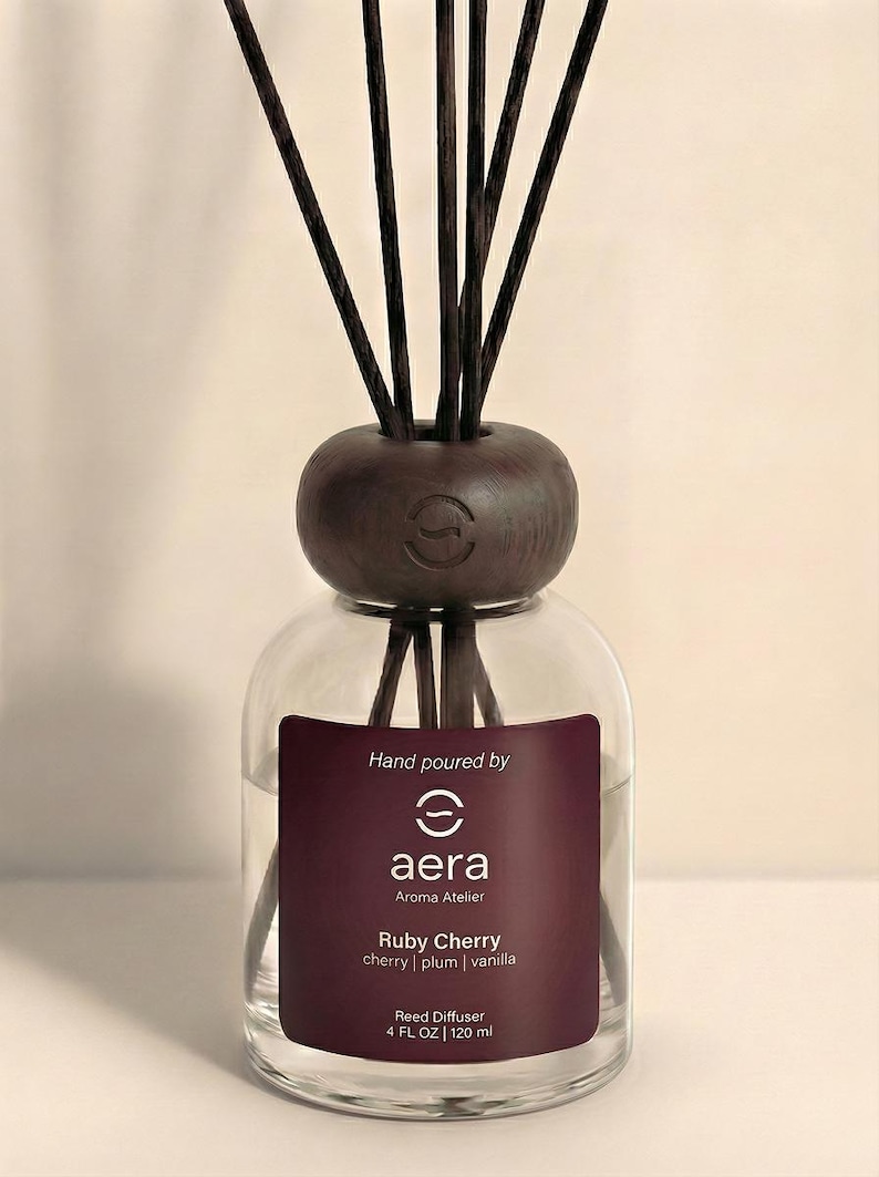 Peut inclure: Diffuseur de roseaux en verre transparent avec un bouchon et des tiges en bois brun fonc&eacute;. L'&eacute;tiquette indique "Ruby Cherry" avec des senteurs de cerise, prune et vanille. Contient 120 ml de parfum.