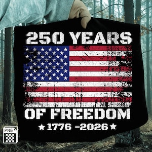 May include: Black t-shirt with a distressed American flag design. The flag features red and white stripes and a blue field with white stars. White text reads "250 YEARS OF FREEDOM" with "1776-2026" below. The shirt is held up by a person.