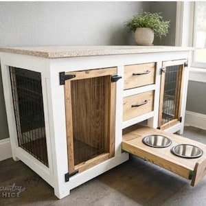 Puede incluir: Una jaula para perros de madera y blanca con encimera de granito. La jaula tiene dos puertas de malla metálica, dos cajones y una bandeja extraíble para la comida con dos cuencos de acero inoxidable. Un mueble para mascotas elegante y funcional.
