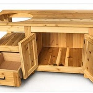 Può includere: Un'isola cucina da esterno in legno marrone chiaro con un ritaglio circolare per una griglia. Dispone di un cassetto, un ripiano e ante. L'isola è realizzata in legno naturale e ha un design semplice e funzionale.