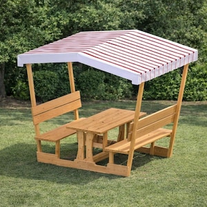 May include: A wooden picnic table set with a striped canopy. The table has attached benches and is made of light-coloured wood. The canopy is white with red stripes. The set is outdoors on a grassy lawn.