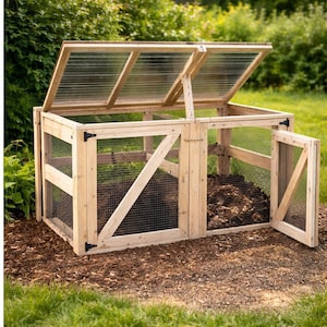 Op de afbeelding: Een houten compostbak met een scharnierend deksel en gaas aan de zijkanten. De bak is gemaakt van lichtgekleurd hout en heeft een gedeeltelijk open deur. Het deksel is transparant en geeft zicht op de inhoud.