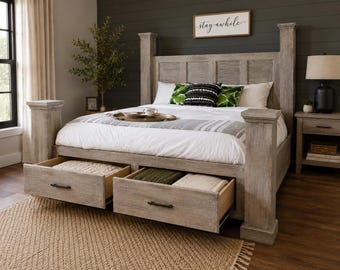 May include: A light gray wooden bed frame with two open drawers. The bed has a headboard with a sign that says "stay awhile". The bed is made with white bedding and decorative pillows. A brown rug is in front of the bed.