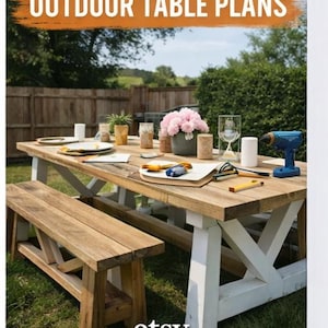 May include: DIY Farmhouse Outdoor Table Plans are featured in this image. A wooden outdoor table with white legs and a matching bench are set up on a grassy lawn. The table is set with plates, glasses, and a vase of pink flowers. A blue drill and tools are on the table.