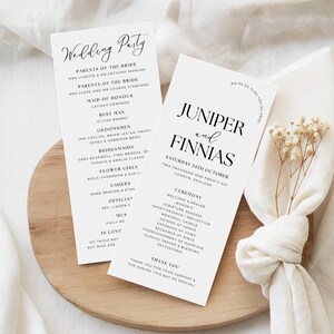 Könnte beinhalten: Zwei weiße Hochzeitskarten mit schwarzem Text, eine mit der Aufschrift "Wedding Party" und die andere mit "Juniper and Finnias". Die Karten listen Namen und Details für eine Hochzeitszeremonie auf, mit einem dekorativen Zweig getrockneter Blumen.