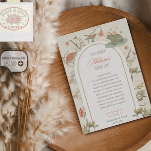May include: A birthday party invitation with floral and frog illustrations. The invitation is on a wooden tray with dried flowers and a white cloth in the background. The invitation reads "Melissa's Birthday Party".