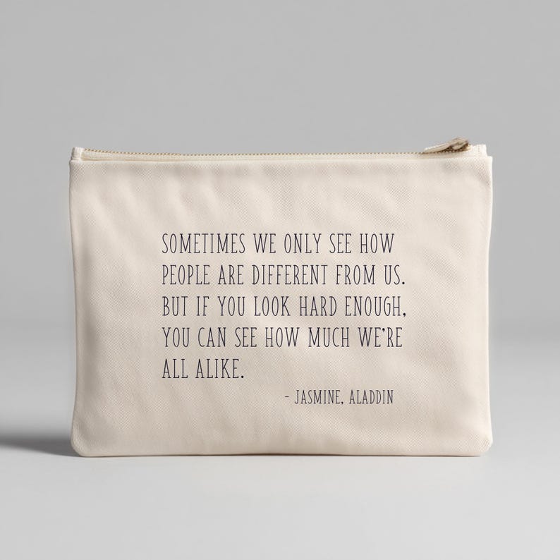 May include: A cream-colored zippered pouch with the quote "Sometimes we only see how people are different from us. But if you look hard enough, you can see how much we're all alike." - Jasmine, Aladdin.