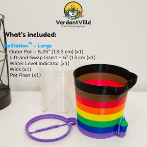 May include: A SipStation Large self-watering planter set featuring a rainbow-striped outer pot, a clear inner insert, a purple pot riser, and a water level indicator. Text lists components: Outer Pot 5.25 inches, Lift-and-Swap Insert 5 inches.