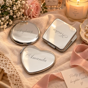 Puede incluir: Tres espejos compactos de metal plateado pulido con tapas abatibles. Uno es redondo con el nombre Sydney, uno es cuadrado con el nombre Kristin y uno tiene forma de corazón con el nombre Amanda grabado en la superficie frontal de cada espejo.