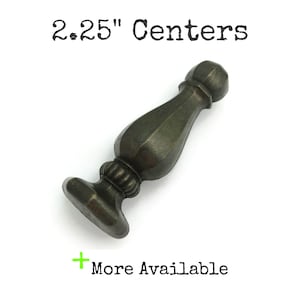 May include: A bronze-colored cabinet pull with a decorative design. The pull measures 2.25 inches between centers. The image includes the text "More Available".