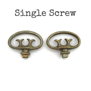 May include: Two antique brass-coloured screws with an oval handle and decorative accents. The screws are displayed on a white background. The text "Single Screw" is printed above the screws.