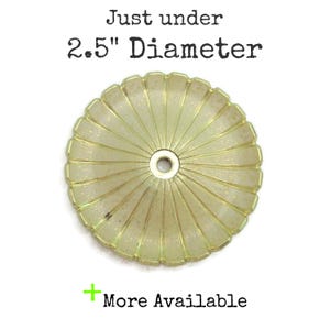 May include: A gold-coloured metal ceiling fixture with a decorative, scalloped edge. The fixture is just under 2.5 inches in diameter.