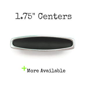 May include: A silver and black cabinet pull with a 1.75" center to center measurement.