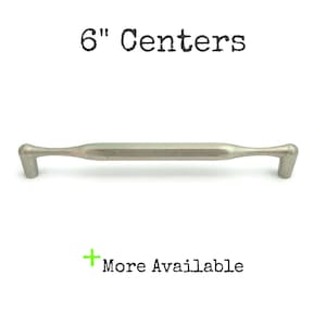 May include: A silver metal cabinet pull with a 6-inch center to center measurement. The pull has a rounded rectangular shape with a slight curve at each end.