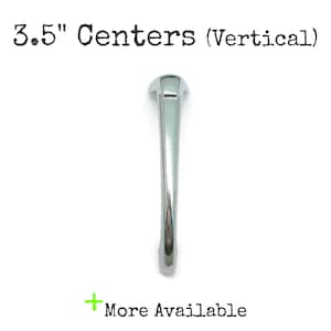 May include: A polished silver-toned metal cabinet handle with a curved, elongated design. The text 3.5" Centers (Vertical) is printed above the handle, and the text + More Available is printed below the handle on a plain white background.