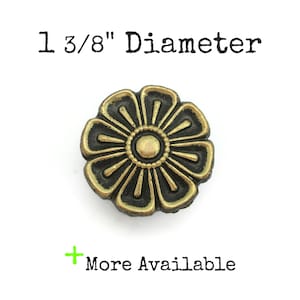 May include: A gold and black metal flower-shaped knob with a 1 3/8" diameter.